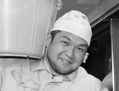 蒸し上がった米を担ぎ、タンクへ運ぶ